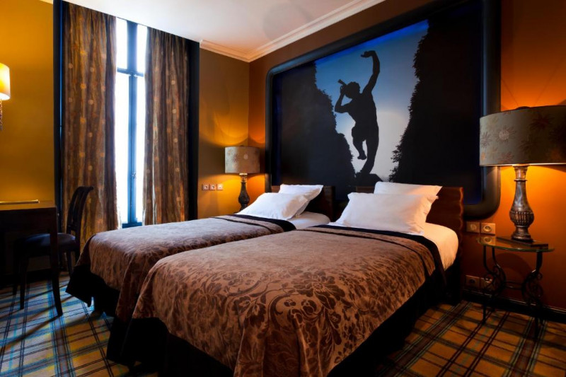 The carpeted room has twin beds with nightstands.There is a workstation, a movable chair and 2 reading lamps.