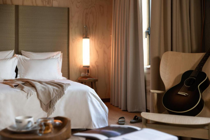 The room has 1 full-sized bed with nightstands, a chair, and a small table.