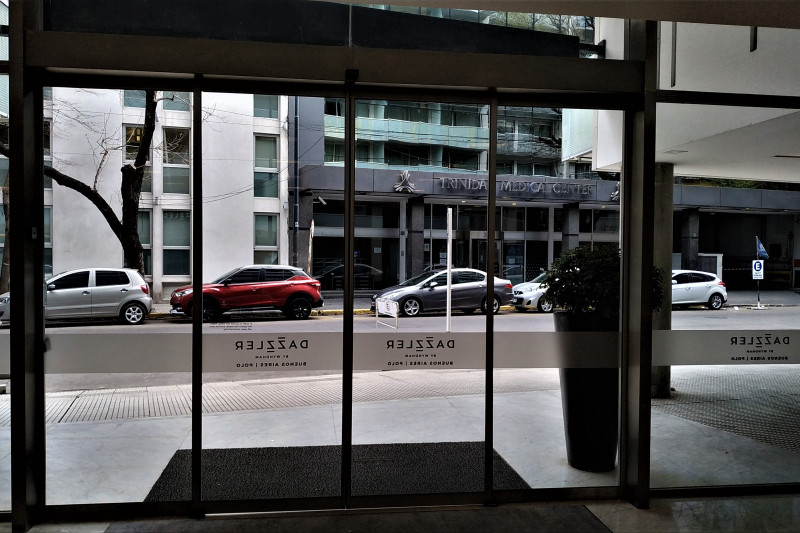 The hotel lobby leads onto the sidewalk through sliding doors.