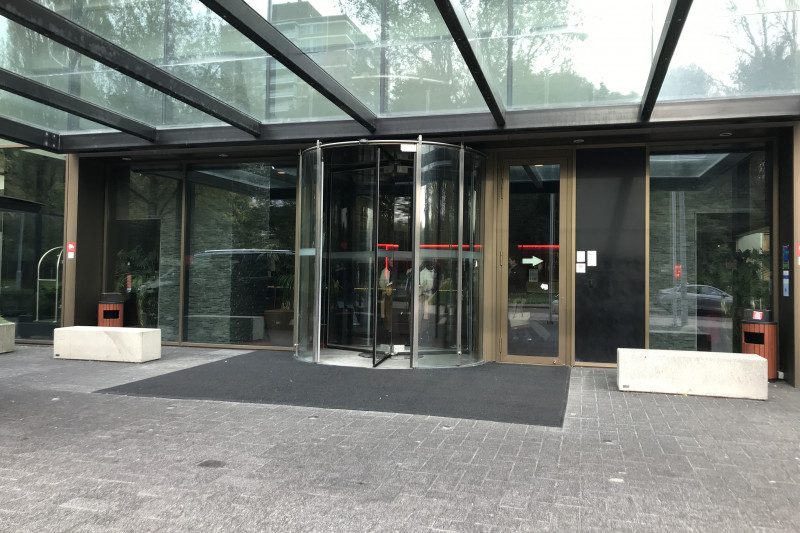 Access to the hotel is from the sidewalk. There is a revolving door and a side door.