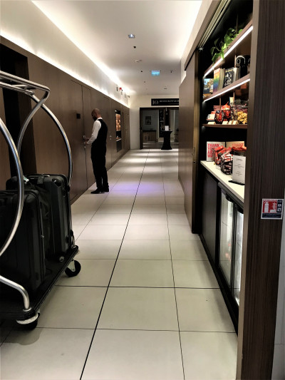 The long, spacious corridor has several built-in wall units and it leads to the Le Dix restaurant. One unit has a sliding door with snacks and books inside.