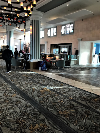 The spacious, step-free lobby has assorted seating. The center of the area is carpeted.