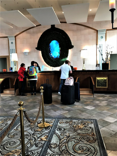 The spacious reception area has a high check-in desk. There are two steps with a handrail in front of the check-in desk.