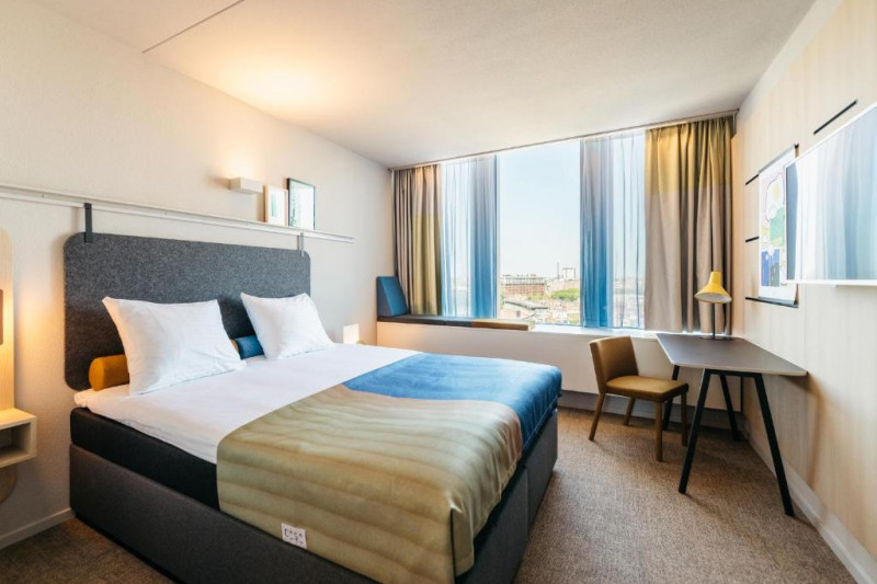 The room has 1 full-size bed with nightstands. There is a workstation, a movable chair and a reading lamp.