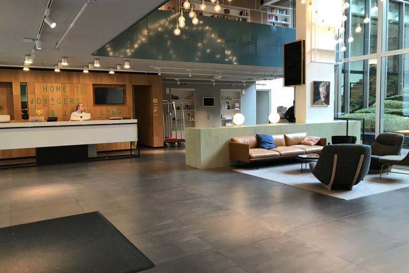 The spacious reception area has a high check-in desk. There are assorted sofas and low tables.