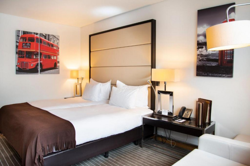 The room has twin beds with nightstands and a sofa bed.