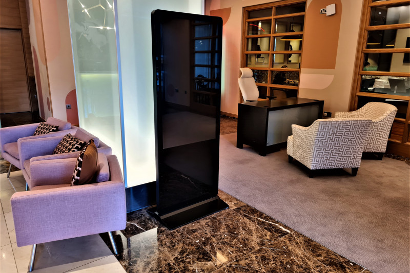 The spacious seating area has a built-in wall unit, a table and armchairs.