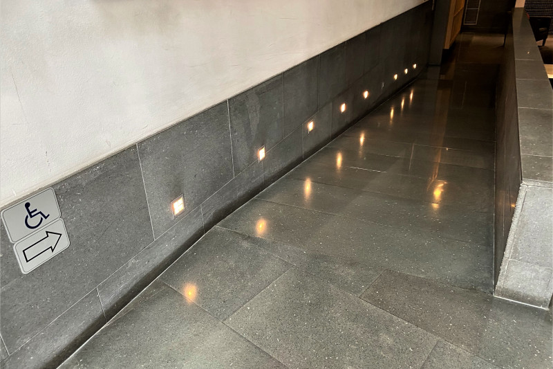 There is a ramp leading down to another area. There are no handrails.