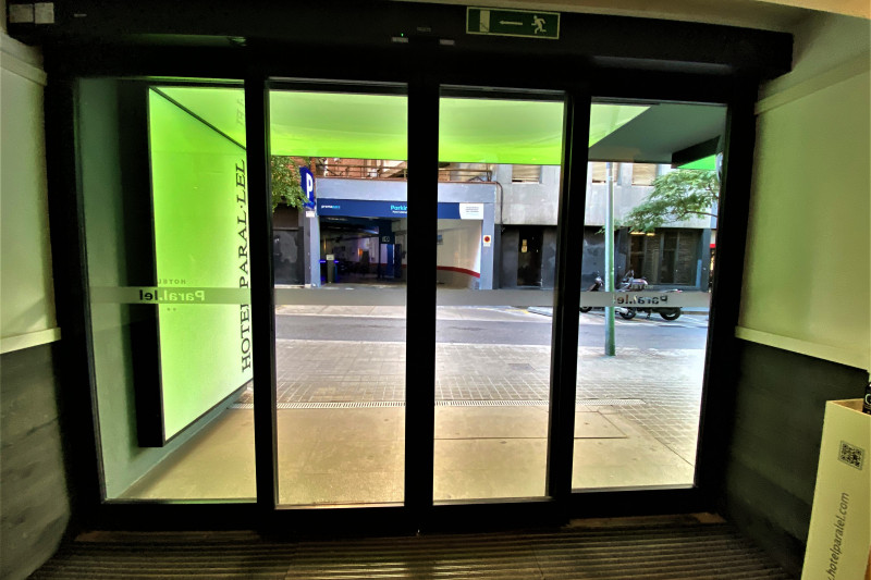 The hotel lobby leads onto the sidewalk through automatic sliding doors.