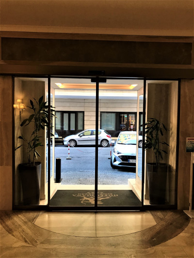 The hotel lobby leads onto the sidewalk through the automatic, sliding doors.