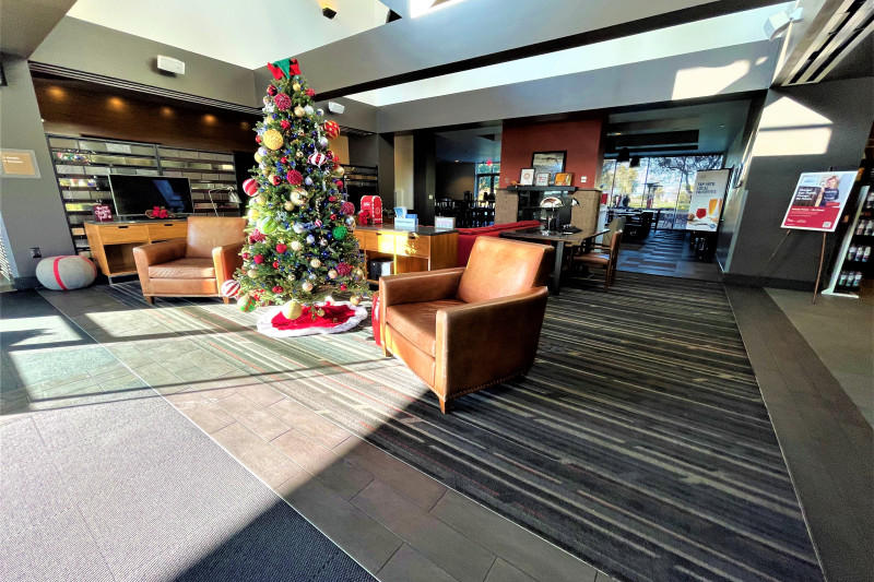The spacious lobby has 2 TV screens, armchairs, sofas, and festive decorations.