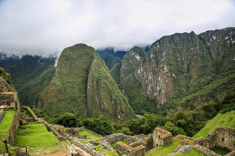 View of green mountains next to ancient Inca constructions in Machu Picchu